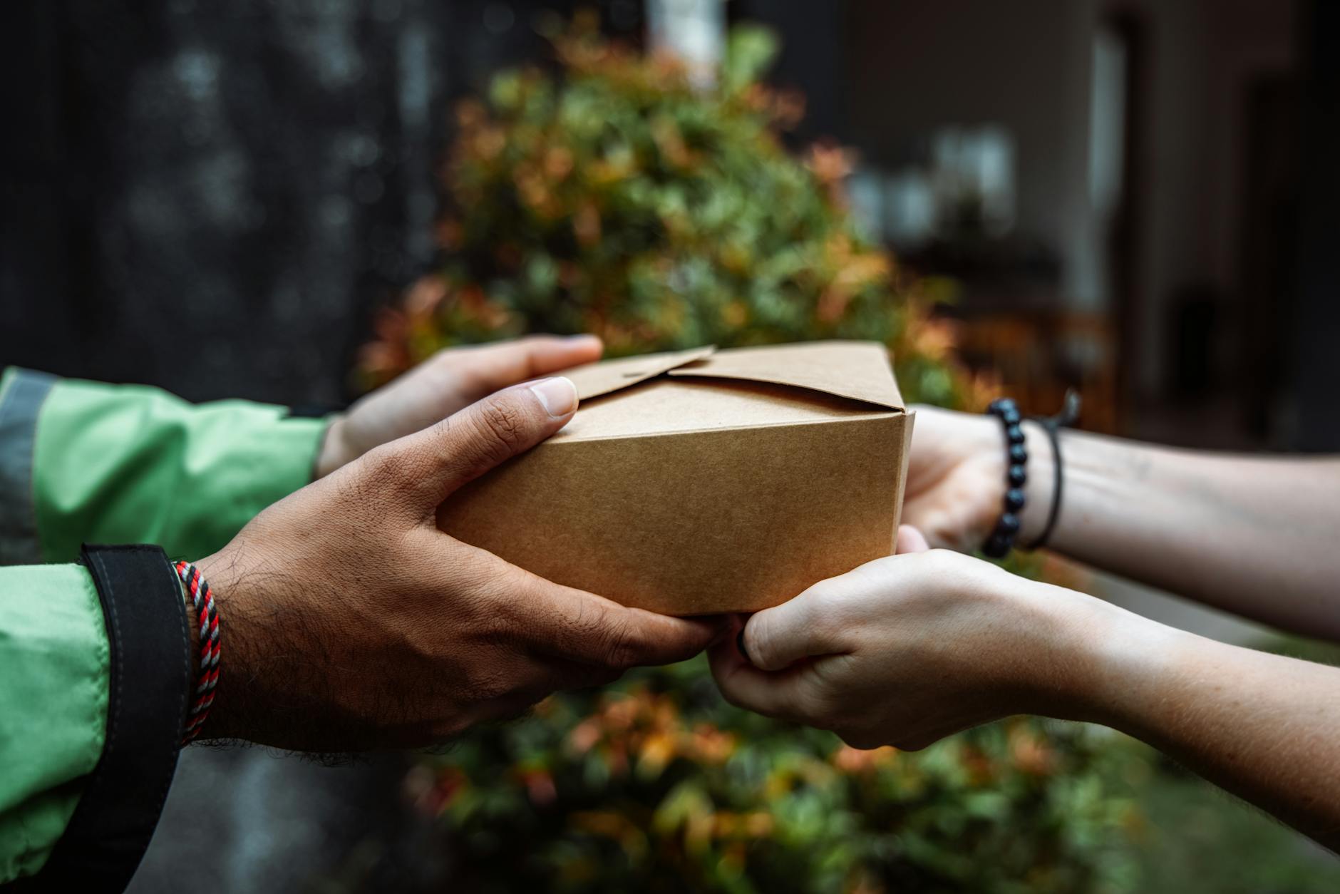 hands holding cardboard takeout box
